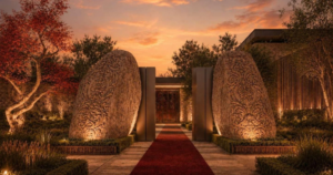 Zora Estate wedding venue with carved stone walls, red flowers, and pathways